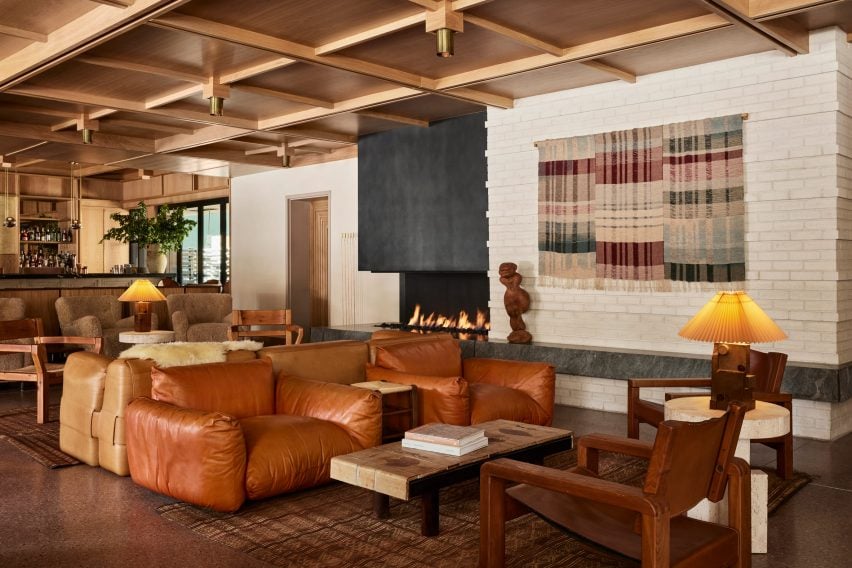 Salón del vestíbulo de Mollie Aspen con muebles en tonos tierra y techo de celosía de madera