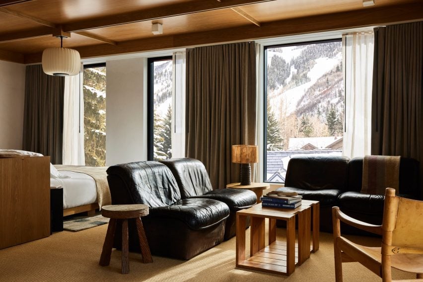 Suite de invitados con muebles de cuero negro y vistas a las montañas nevadas