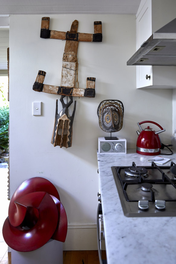 En la cocina monomural, XVIII.  Una máscara africana de madera de finales del siglo XIX cuelga de la pared y una escultura de metal de Russell McQuilty se encuentra en el piso de madera.