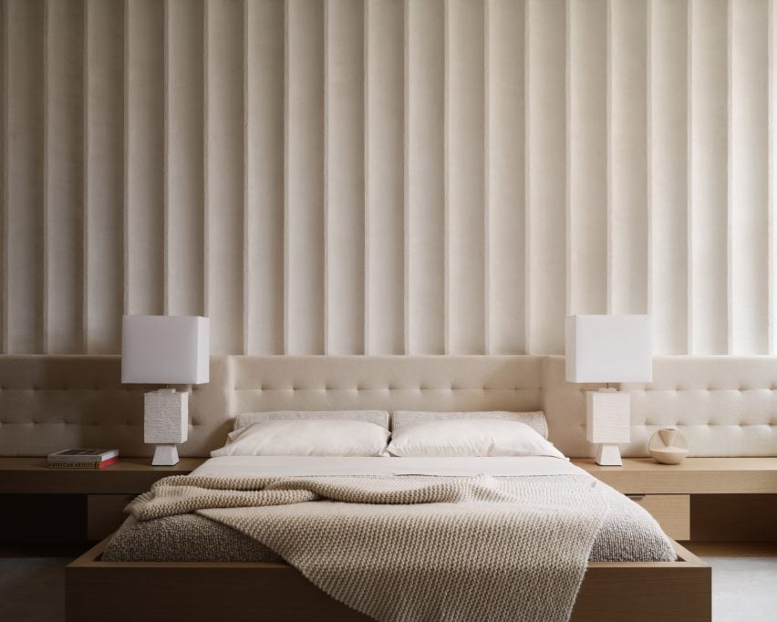 Una pared acanalada detrás de una cama.