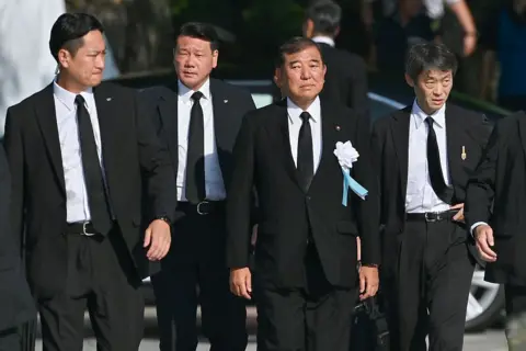 Getty Images Ishiba con traje negro. Otros hombres están llenos de atuendos negros.