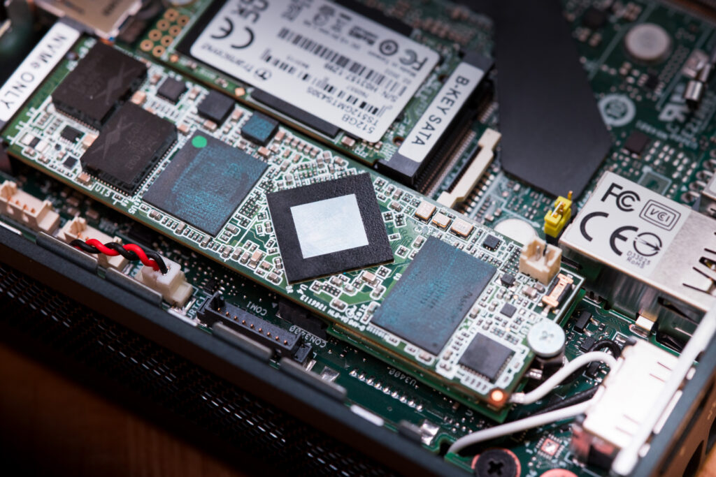 Las imágenes muestran los componentes internos de un dispositivo electrónico que probablemente sea una computadora o un hardware similar. La tabla de circuito verde impreso (PCB) es visible, incluidos los circuitos integrados (ICS), incluidos los condensadores y conectores integrados. 