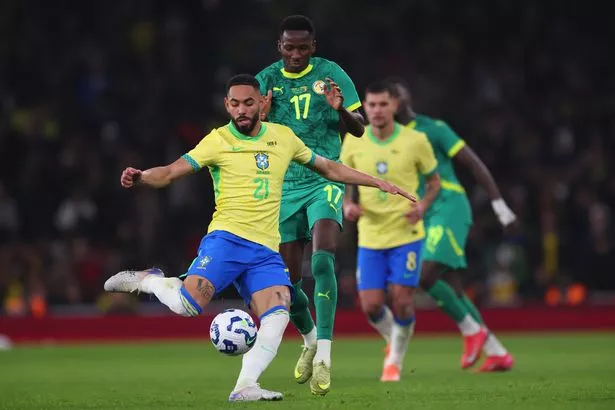 El brasileño Matheus Cunha compite por la posesión con el senegalés Pape Matar Sarr