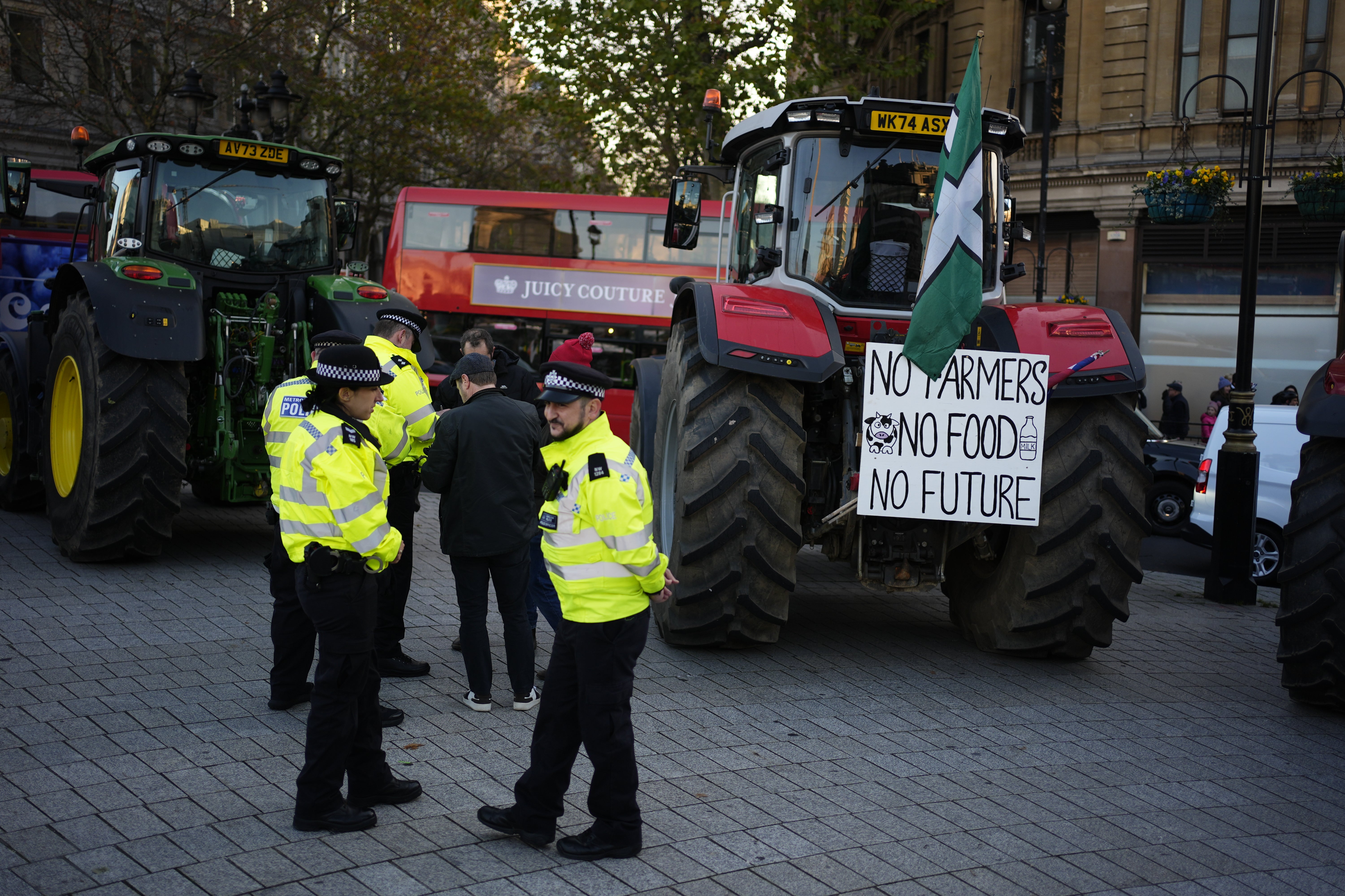 Los agentes de policía hablan con los agricultores que participan en la protesta.