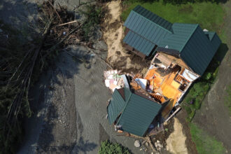 St. Una vista aérea de una casa parcialmente derrumbada en Johnsbury, Vermont, el 30 de julio de 2024, después de que las inundaciones azotaran el área. Vermont, junto con Nueva York, aprobó leyes de superfondo climático el año pasado, y existe una legislación similar en algunos otros estados. Crédito: Danielle Parhizkaran/The Boston Globe vía Getty Images