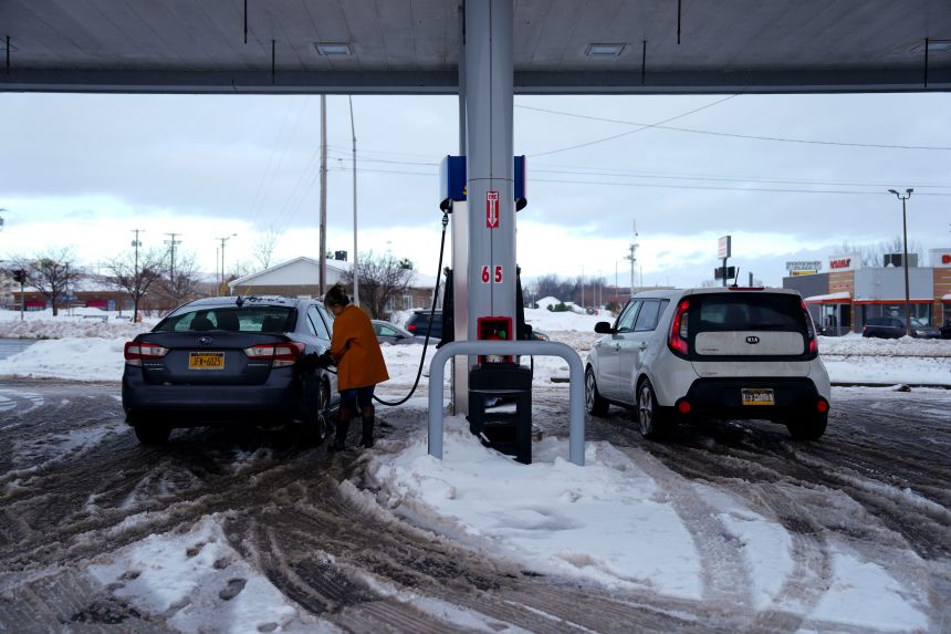 WATERTOWN, NUEVA YORK - 5 DE DICIEMBRE: Mary Lefevre llena gasolina en una gasolinera Sunoco sin pavimentar durante una tormenta de nieve el 5 de diciembre de 2024 en Watertown, Nueva York. (Foto de Kayla Bartkowski/Getty Images)