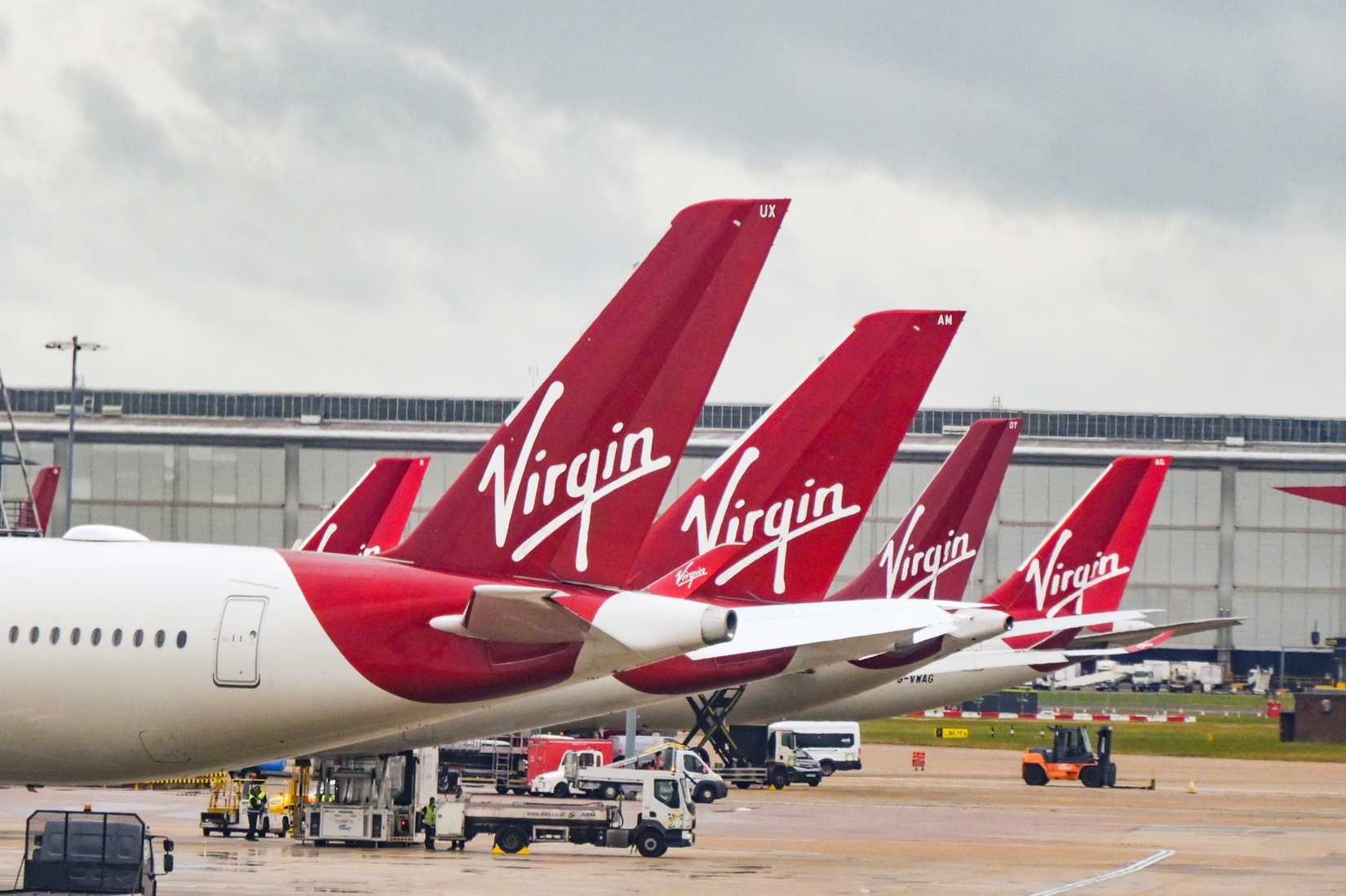 Fila de aletas traseras de aviones de pasajeros de Virgin Atlantic Airways en el aeropuerto de Heathrow en Londres.