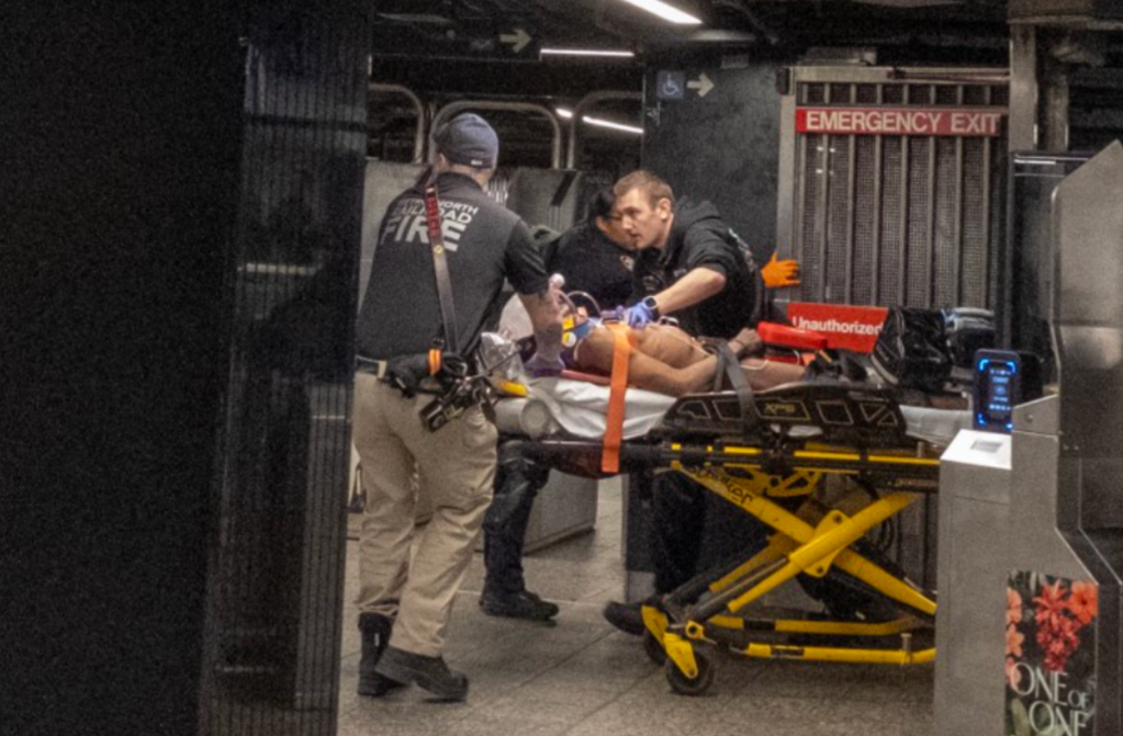 Personal médico de emergencia atendiendo a un paciente en camilla en lo que parece una estación de metro.